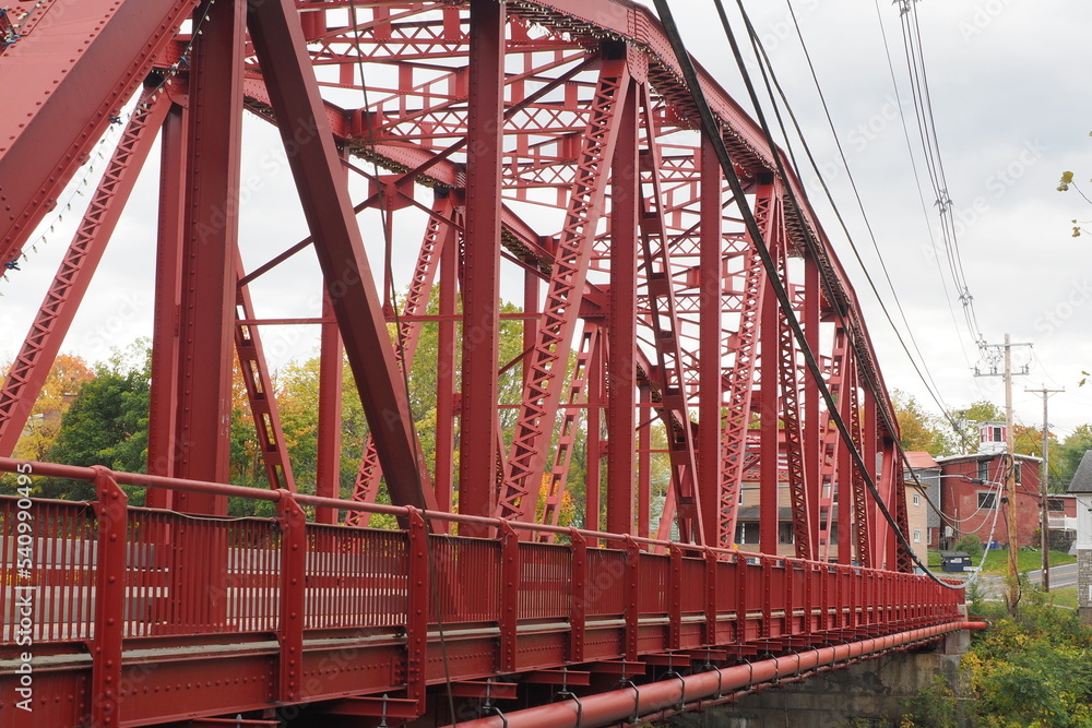 The red bridge crosses over the river in this small rural town. The red bridge crosses over the river in this small rural town.