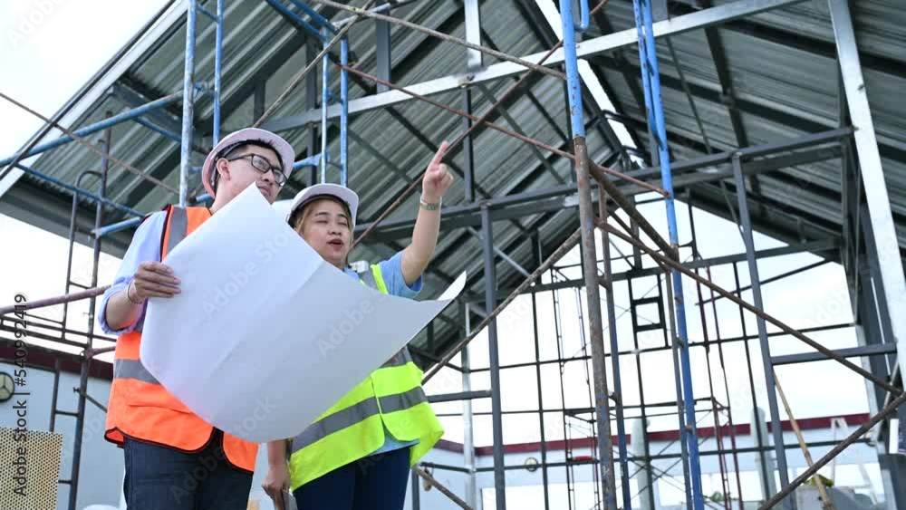 Young engineers working,Plan for construction of a warehouse,See the construction drawings for the storage facility. Young engineers working,Plan for construction of a warehouse,See the construction drawings for the storage facility.