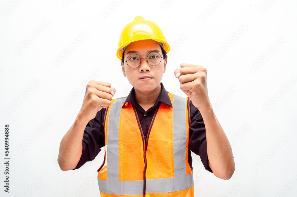 young asian male construction worker or engineer shows expresion of anger and furious looking for fight and threatening isolated over. stressed over work concept