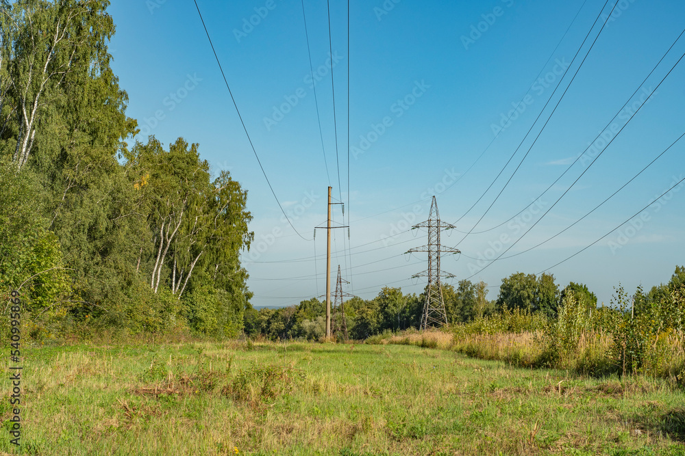 Power line towers. Out-of-town power supply system. Energy infrastructure in the fields in the countryside. Power line towers. Out-of-town power supply system. Energy infrastructure in the fields in the countryside.