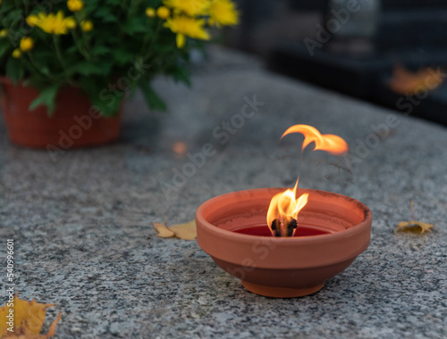 Burning candle on the tombstone. Flame symbolizing the memory of the dead. A candle with a large flame.