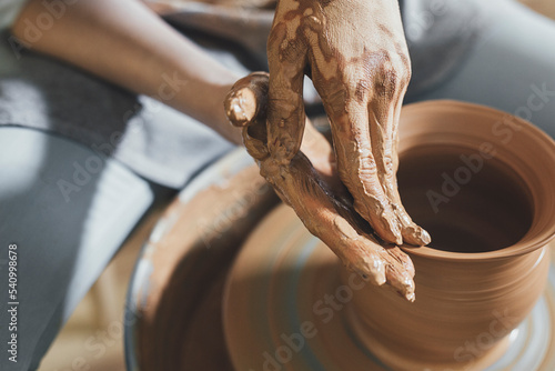 High angle view of potter shaping clay on spinning wheel at workshop photo