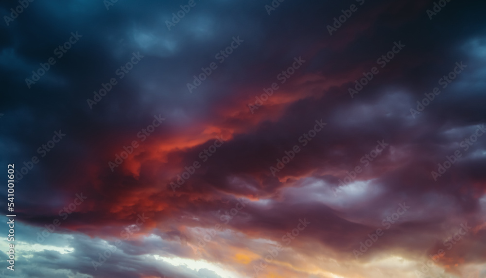 Dramatic clouds in the sky at beautiful red sunset. Nature landscape background