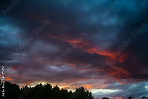 Dramatic clouds in the sky at beautiful red sunset. Nature landscape background