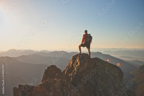 Backpacker standing on mountain peak, North Cascades National Park, Washington State, USA photo