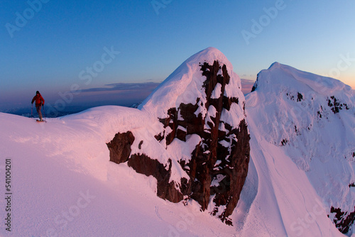 Skier hiking on high alpine ridge at sunet. photo