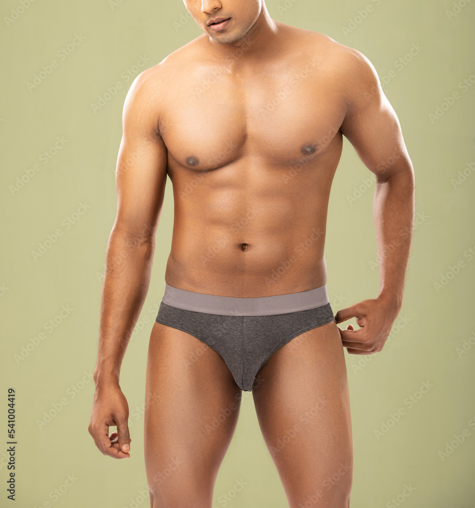 Cropped shot of muscular young man wearing underwear isolated on white background. 