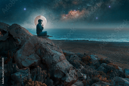 silhouette of a person meditating on a hill at night with milky way and full moon background