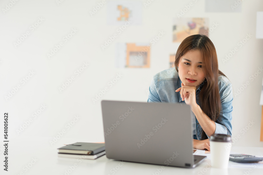 Construction design concept, Female architect use calculator and looks house plan project on laptop Construction design concept, Female architect use calculator and looks house plan project on laptop