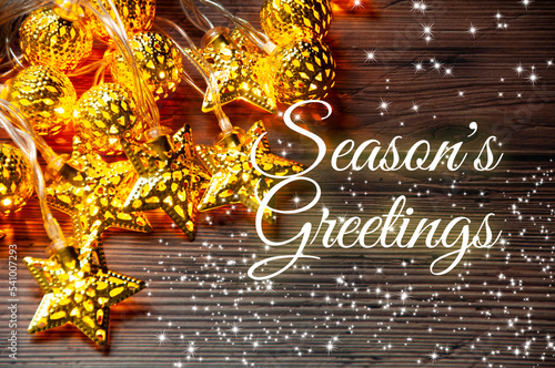 Season's greetings text with golden ball and star of Christmas decoration. Season's greetings and Christmas celebration concept