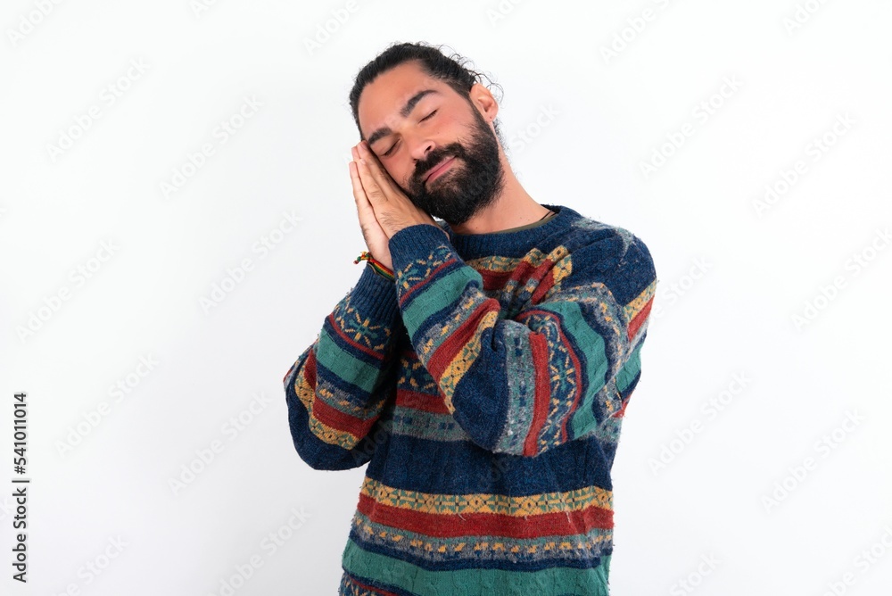 Caucasian man with beard wearing sweater over white background leans on pressed palms closes eyes and has pleasant smile dreams about something Caucasian man with beard wearing sweater over white background leans on pressed palms closes eyes and has pleasant smile dreams about something