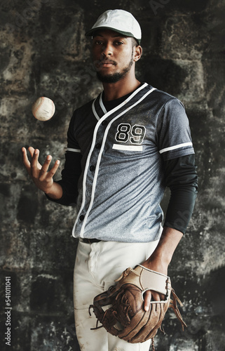 Photography Baseball, sports and uniform with a man athlete on a dark background wearing a mitt while holding a ball