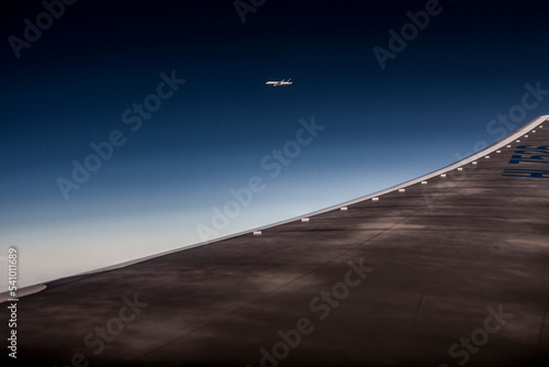 An airplane visible in flight from the window seat of another.