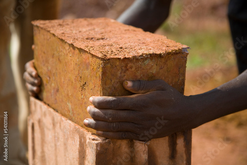 Hands lifting a homemade mud brick photo