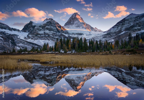 Clouds and peaks reflecting in a small alpine tarn. photo