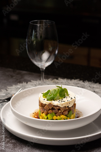 Tuna tartar. Tuna cut into small cubes mixed with soy and spicy and avocado bed

 photo