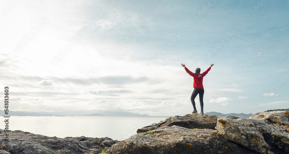 Woman with raised arms enjoying the view Woman with raised arms enjoying the view