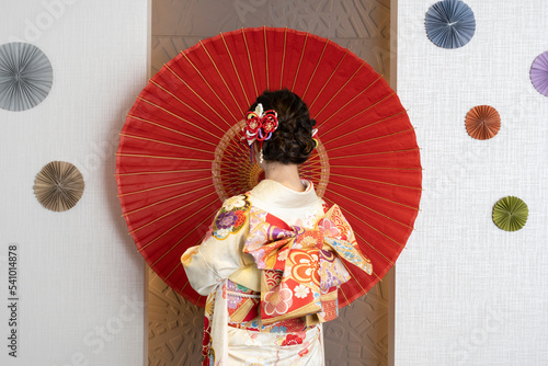 Female adult in kimono with an umbrella spread photo