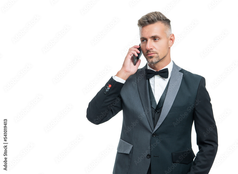 businessman in tuxedo speaking on smartphone isolated on white background
