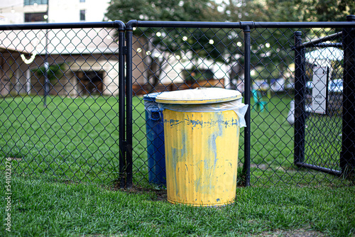 Large yellow trash is set in the lawn photo