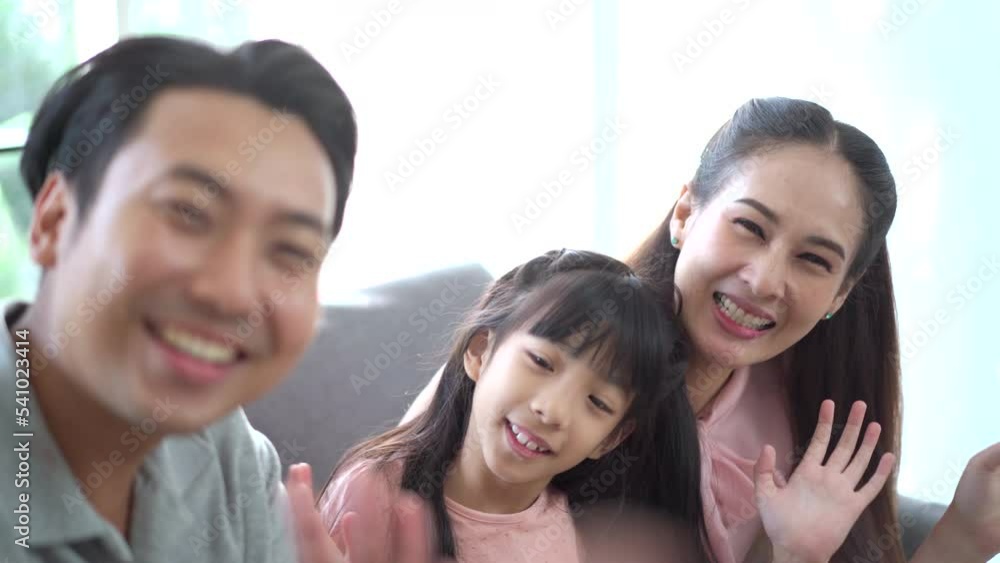 Happy Asian family father, mother, and daughter waving a hands to camera. Happy Asian family father, mother, and daughter waving a hands to camera.