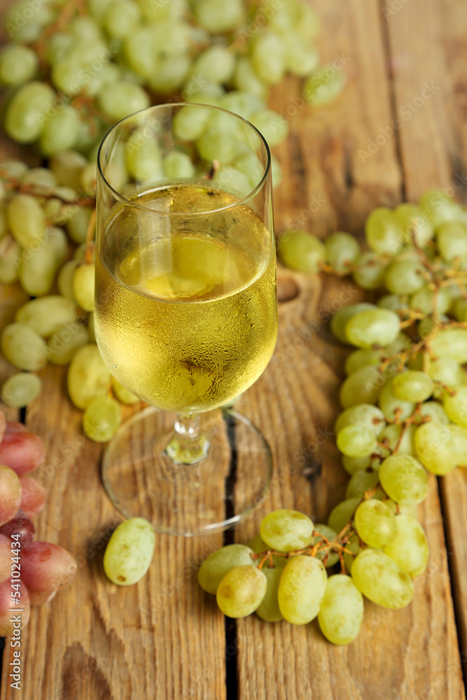 glass of wine with grapes on wooden table glass of wine with grapes on wooden table
