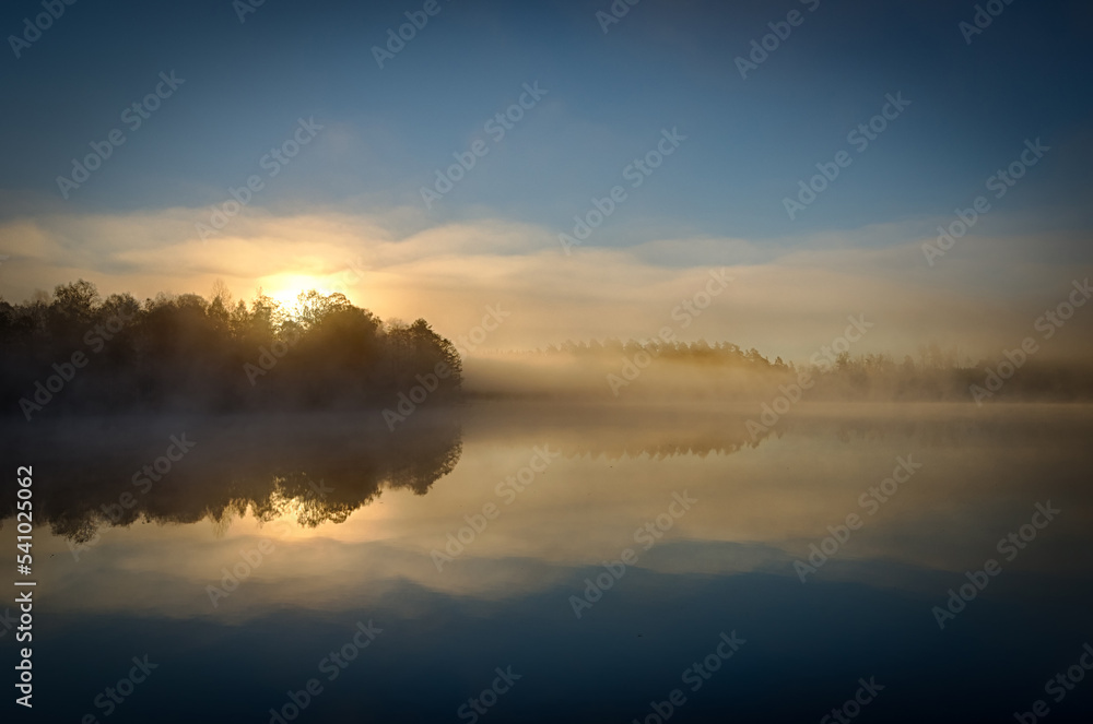 Sunrise over the foggy lake