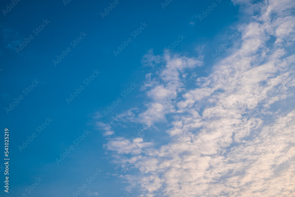 Altocumulus clouds with blue sky in the morning. Middle level layer clouds, extraordinary cloud formation, winter season is coming concept.