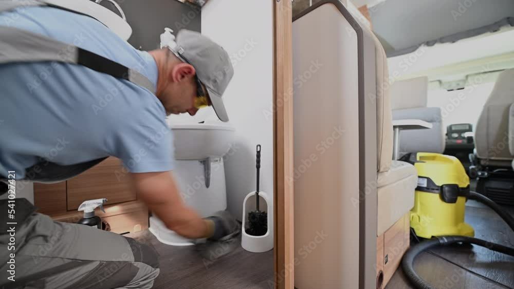 Worker Clean and Disinfect a RV Camper Van Toilet Bowl Worker Clean and Disinfect a RV Camper Van Toilet Bowl