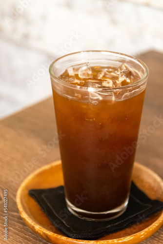Iced americano on wooden table. Cold drink made with ice, espresso, and chilled water.
