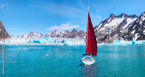 Knud Rasmussen Glacier near Kulusuk with lone yacht with red sails - Greenland, East Greenland photo