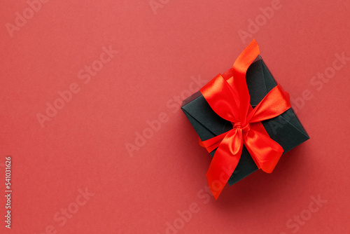 Black box with red bows on dark red background. Singles day 11.11 concept. Online shopping sale.