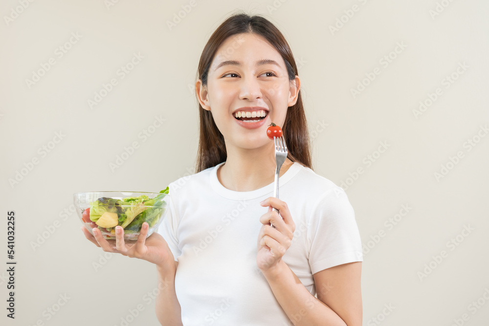 Diet, Dieting asian young woman or girl use fork at tomato on mix vegetables, green salad bowl, eat  food is low fat good health. Nutritionist female, Weight loss for healthy person.