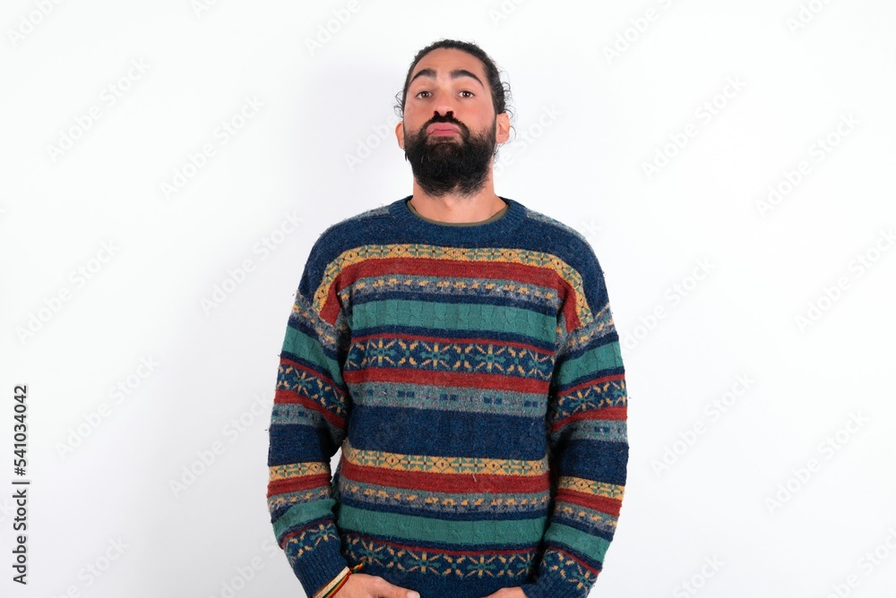 Portrait of lovely funny Caucasian man with beard wearing sweater over white background sending air kiss Portrait of lovely funny Caucasian man with beard wearing sweater over white background sending air kiss