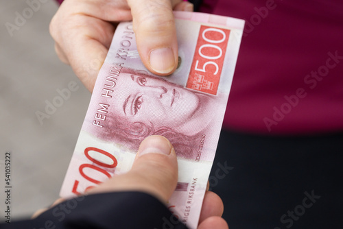 Two people donate banknote, SEK 500, financial concept, Swedish money