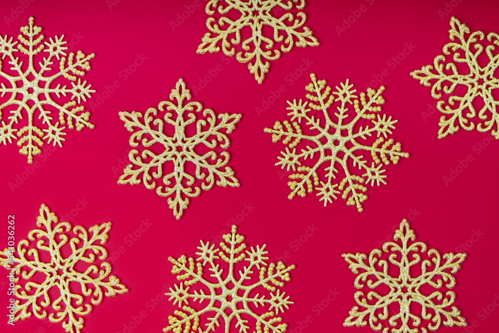 Golden glitter decorative snowlakes on red background. Christmas and New Year holiday wallpaper. Top view, flat lay, copy space, banner, hearder, mockup, backdrop Golden glitter decorative snowlakes on red background. Christmas and New Year holiday wallpaper. Top view, flat lay, copy space, banner, hearder, mockup, backdrop
