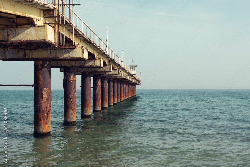 Old and rusty pier in the sea.