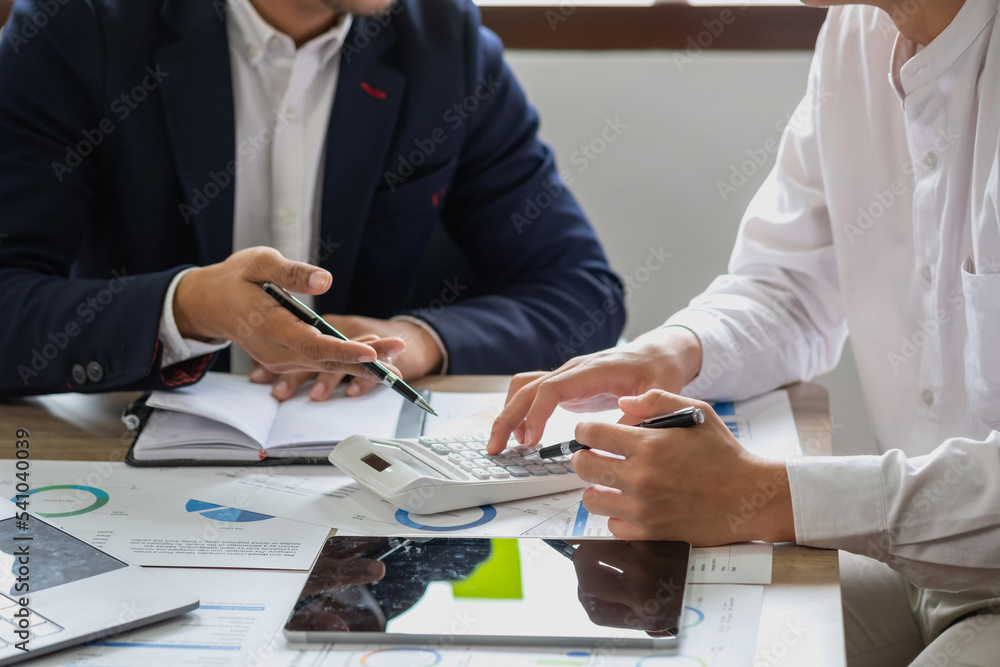 Team of business use calculators and graph analysis computer laptop tablets to plan marketing strategies and make profitable investments for the company. Team of business use calculators and graph analysis computer laptop tablets to plan marketing strategies and make profitable investments for the company.