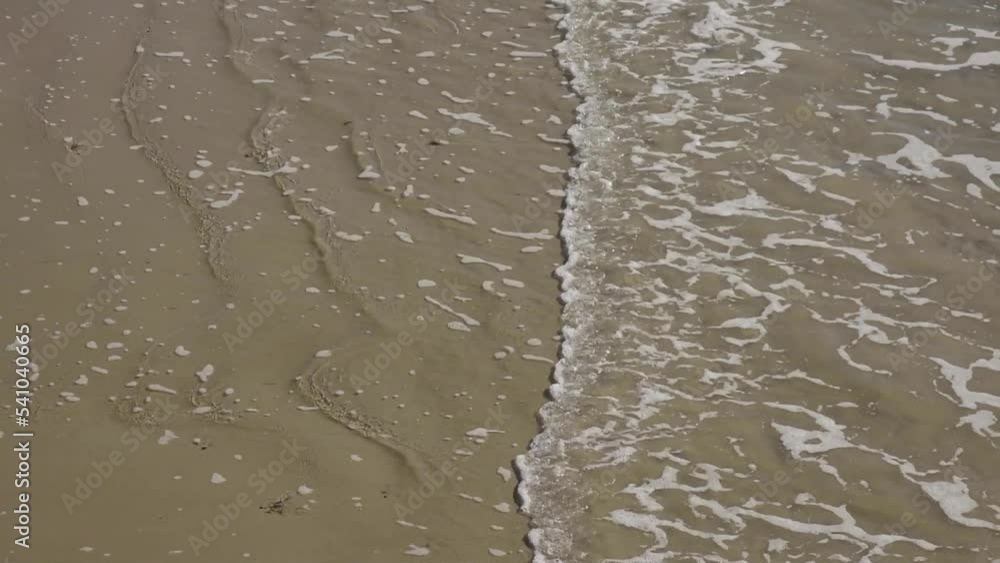 Gentle wave motion of sea water on sandy beach Gentle wave motion of sea water on sandy beach