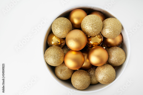 a cone full of golden Christmas balls with white background and space for copying