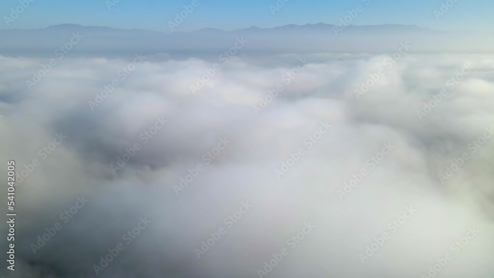 Aerial shot of flying over a layer of soft clouds at dawn Aerial shot of flying over a layer of soft clouds at dawn