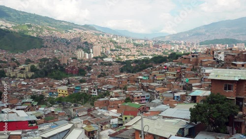 Panning shot of Comuna 13 slum in Medellin, Colombia. Once one of the most dangerous neighbourhoods in the country, the Comuna 13 reinvented itself in recent times and is now considered safe to visit.