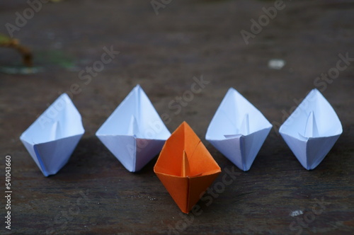 A group of paper boats on a colored background. © Станислав 