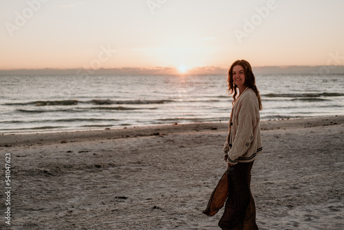 woman smiling on beach at sunset