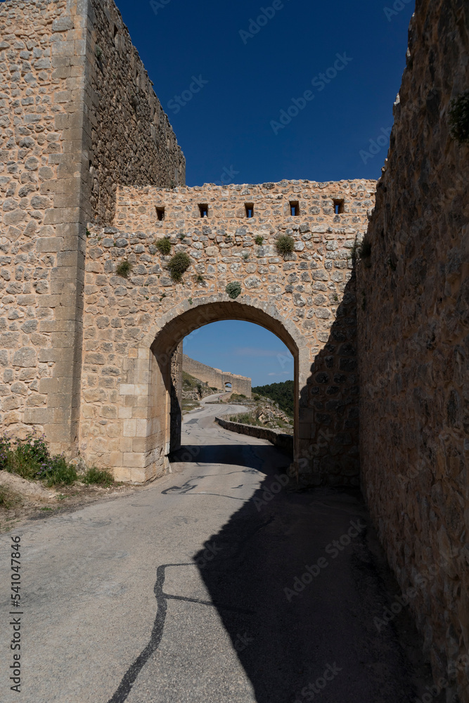 entrance road to the castle with its walls and bridge in rustic stones