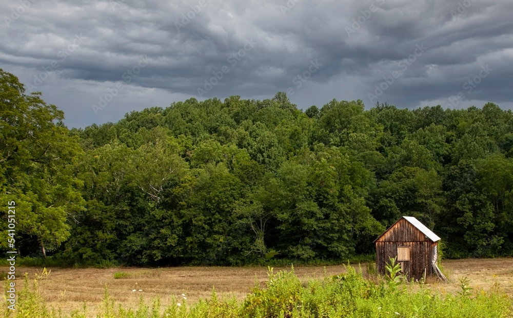 Farm outbuilding under threatening cloudy sky. 