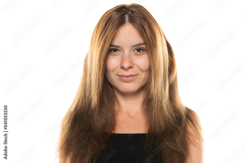 portrait of a young smiling woman without make up and with long hair on a white background portrait of a young smiling woman without make up and with long hair on a white background