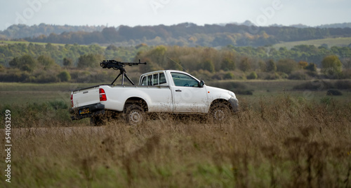 white toyota hilux pickup truck converted with an army large calibre machine gun on the rear deck