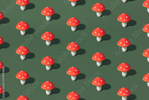 Red and white mushroom on a green background. Pattern.