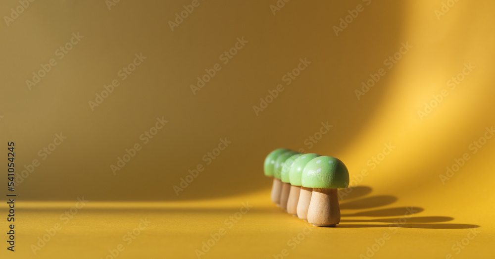 Wooden mushrooms on a cream-colored background. Copy space.
